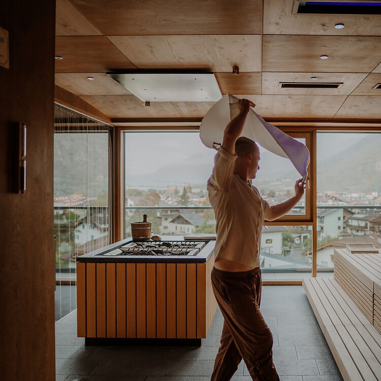 Maestro della sauna durante il versamento nella sauna panoramica dello Sky Spa