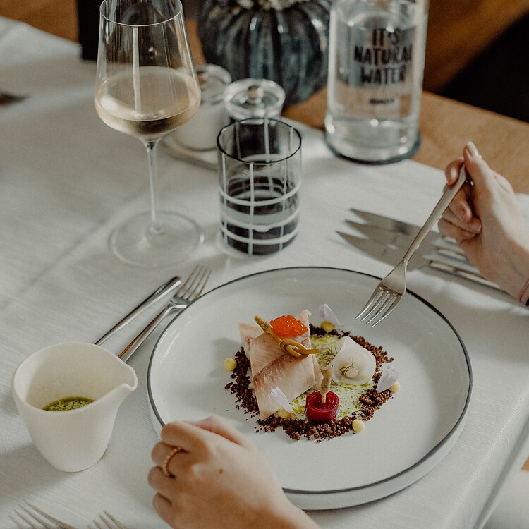 Ospite che gusta il piatto principale durante la cena in hotel