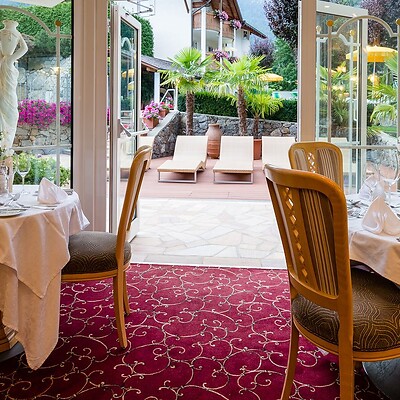 Zona ristorante nel precedente Jagdhof con vista sul giardino dell’hotel