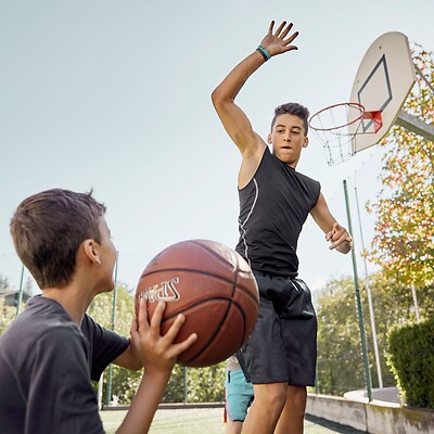 Bambini che giocano a basket nel parco avventura all’aperto