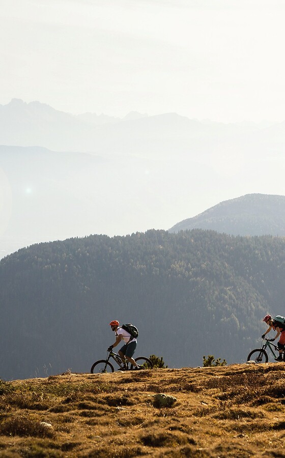 Gruppo in e-mountain bike su un sentiero di montagna con panorama montano