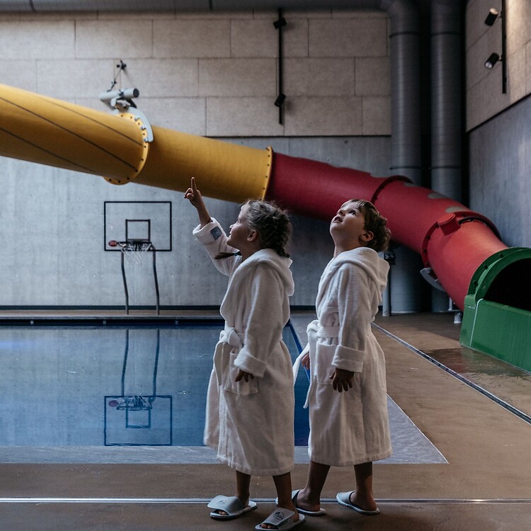 Kinder im Family Spa und im Hintergrund die große Wasserrutsche