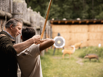 Boy learning archery on the outdoor archery course