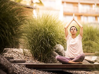 Woman relaxing while doing yoga in the garden