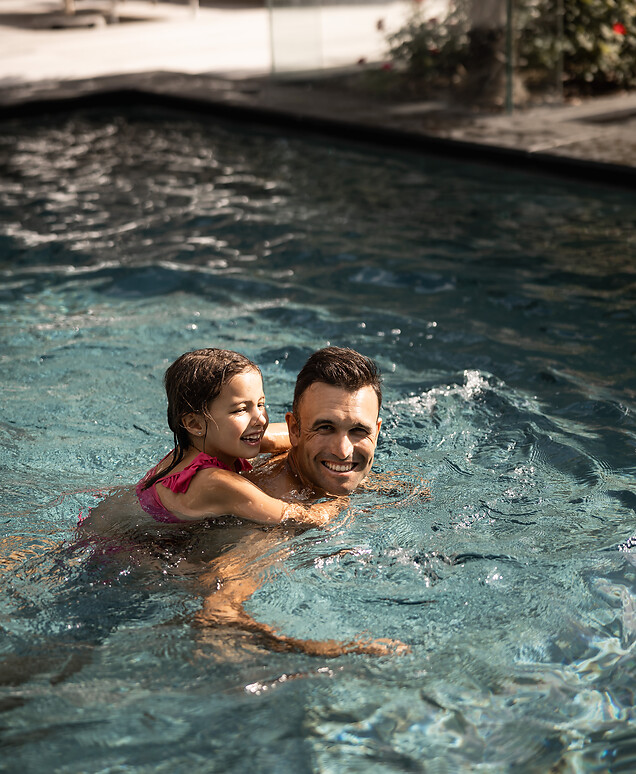 Father and daughter swimming in the outdoor thermal pool