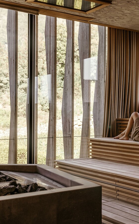 Woman lying in the sauna with a view of the thermal garden