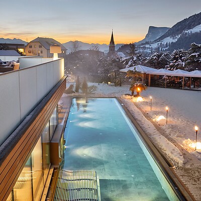 Heated outdoor sports pool with snow-covered garden and mountains