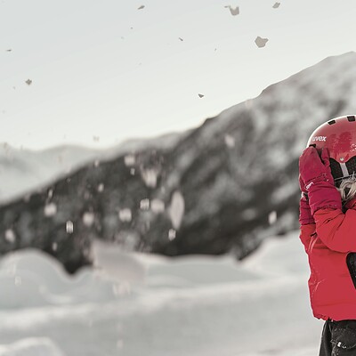 Girl in ski suit on ski slope in the mountains