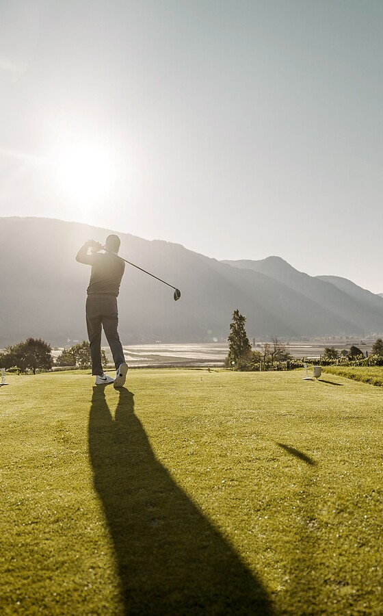 Golfer teeing off on a sunny mountain course