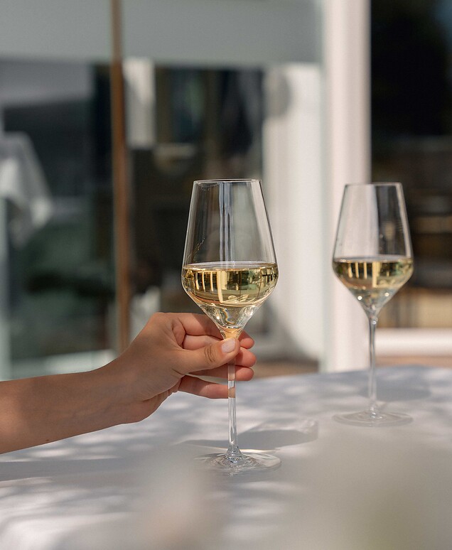 Gast genießt ein Glas Prosecco auf der Sonnenterrasse