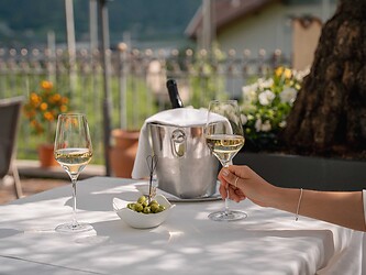 Gast genießt ein Glas Prosecco auf der Sonnenterrasse