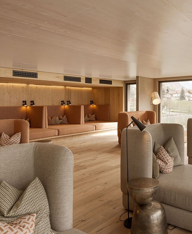 Moderner Ruheraum aus Holz mit Polsterliegen und Fensterfront mit Bergpanorama