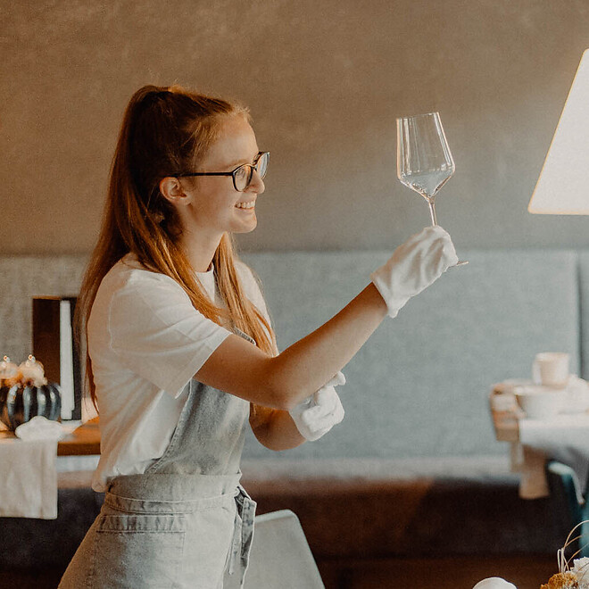 Addetto al servizio mentre prepara i tavoli per la cena