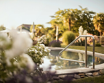 Naturpool im mediterran blühenden Hotelgarten im Frühling