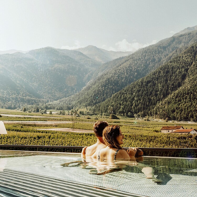 Frau und Mann im Rooftop Whirlpool mit Blick über die Obstplantagen