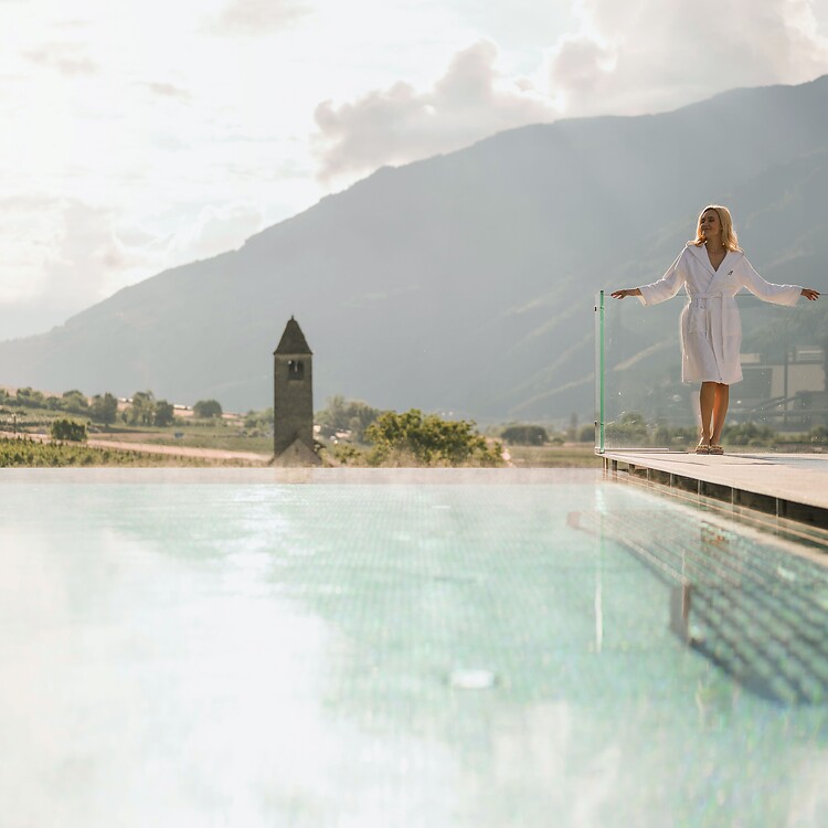 Frau genießt den Ausblick auf der Sky Spa Terrasse mit dem Thermalwasserpool