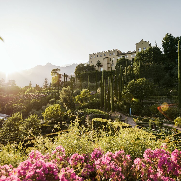 Sonne scheint auf das blühende Schloss vom Trauttmansdorff