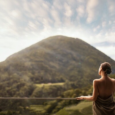 Frau steht auf der Terrasse mit Aussicht auf die Berge