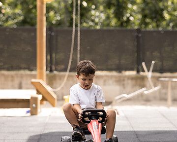Kind beim Spielen im hoteleignen Outdoorspielplatz
