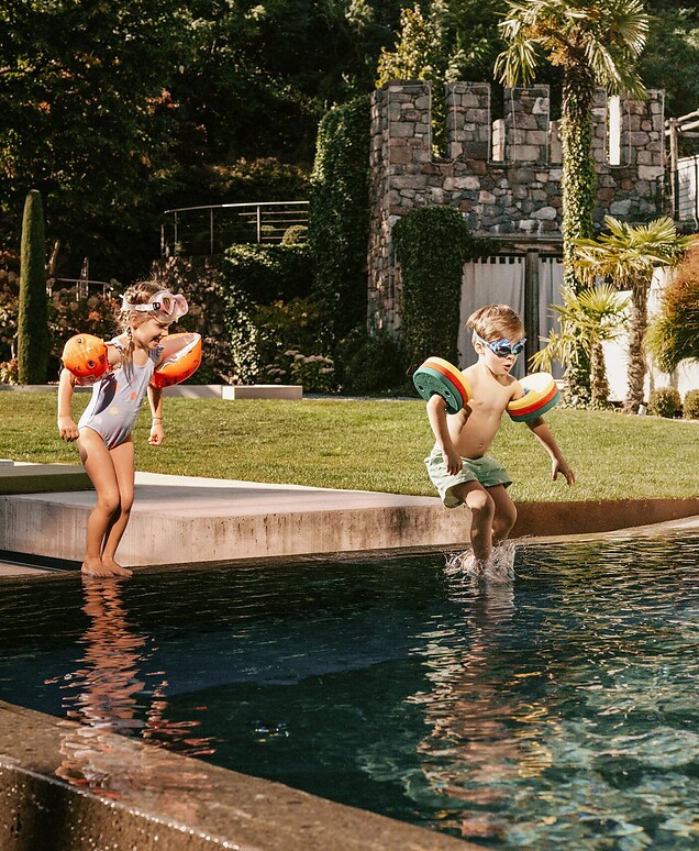 Kinder springen in den Outdoor-Thermalwasser-Pool