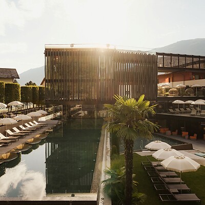 Wellness Tower with sports pool, sun loungers, and hotel garden at sunrise