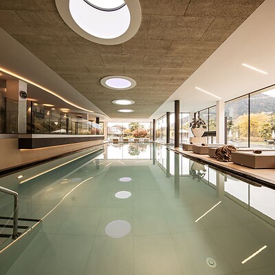 Indoor pool with lounge chairs and a view of nature