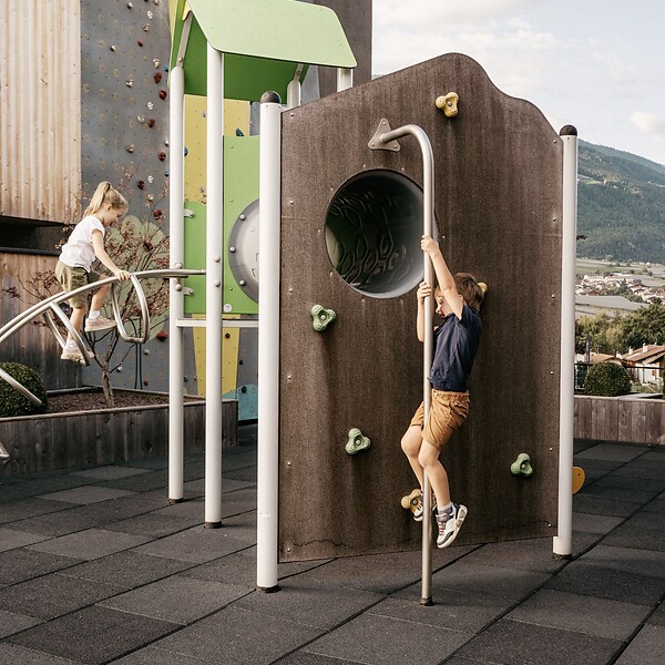 Kinder spielen im hoteleigenen Outdoor-Spielplatz