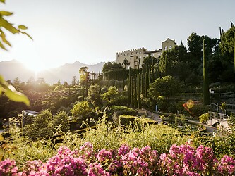 Sonne scheint auf das blühende Schloss vom Trauttmansdorff