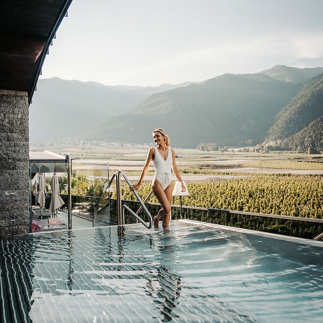 Frau beim Rooftop-Whirlpool mit Blick über die Apfelplantagen