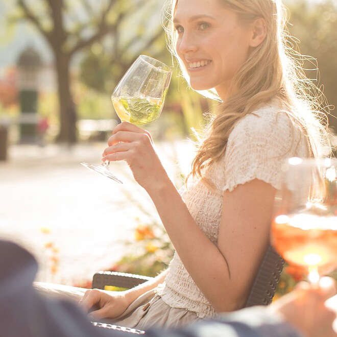Frau und Mann genießen einen Aperitif auf der Promenade in Meran