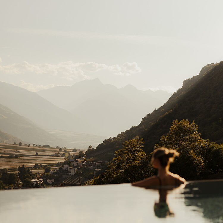 Frau im Infinity Sky Pool blickt auf das Bergpanorama