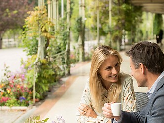 A man and a woman enjoying a coffee on the Winter Promenade in Merano