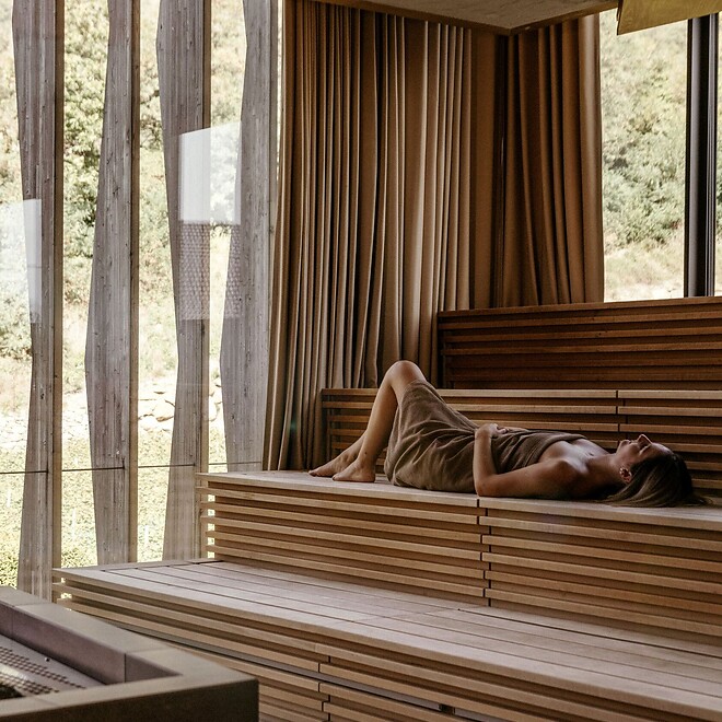 Woman lying in the sauna with a view of the thermal garden