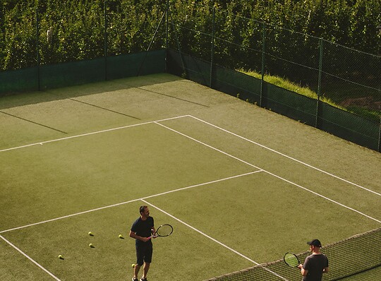 Hoteleigener Tennisplatz umgeben von Bergen
