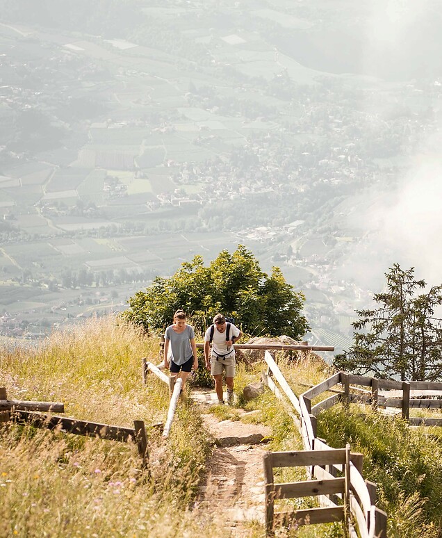 Mann und Frau wandern im Berg mit weiter Talaussicht