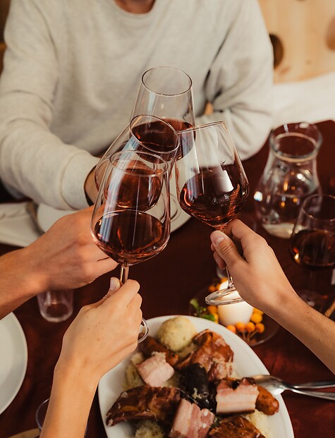 Beim Törggelen mit einem Glas Rotwein anstoßen